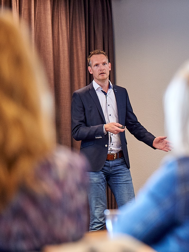 Rick Evers staat voor een groep te praten